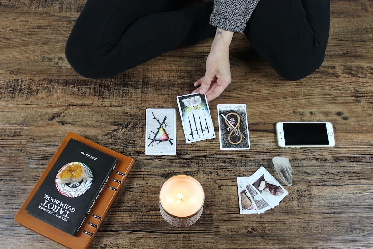 person sat on floor doing tarot reading with wild unknown tarot deck