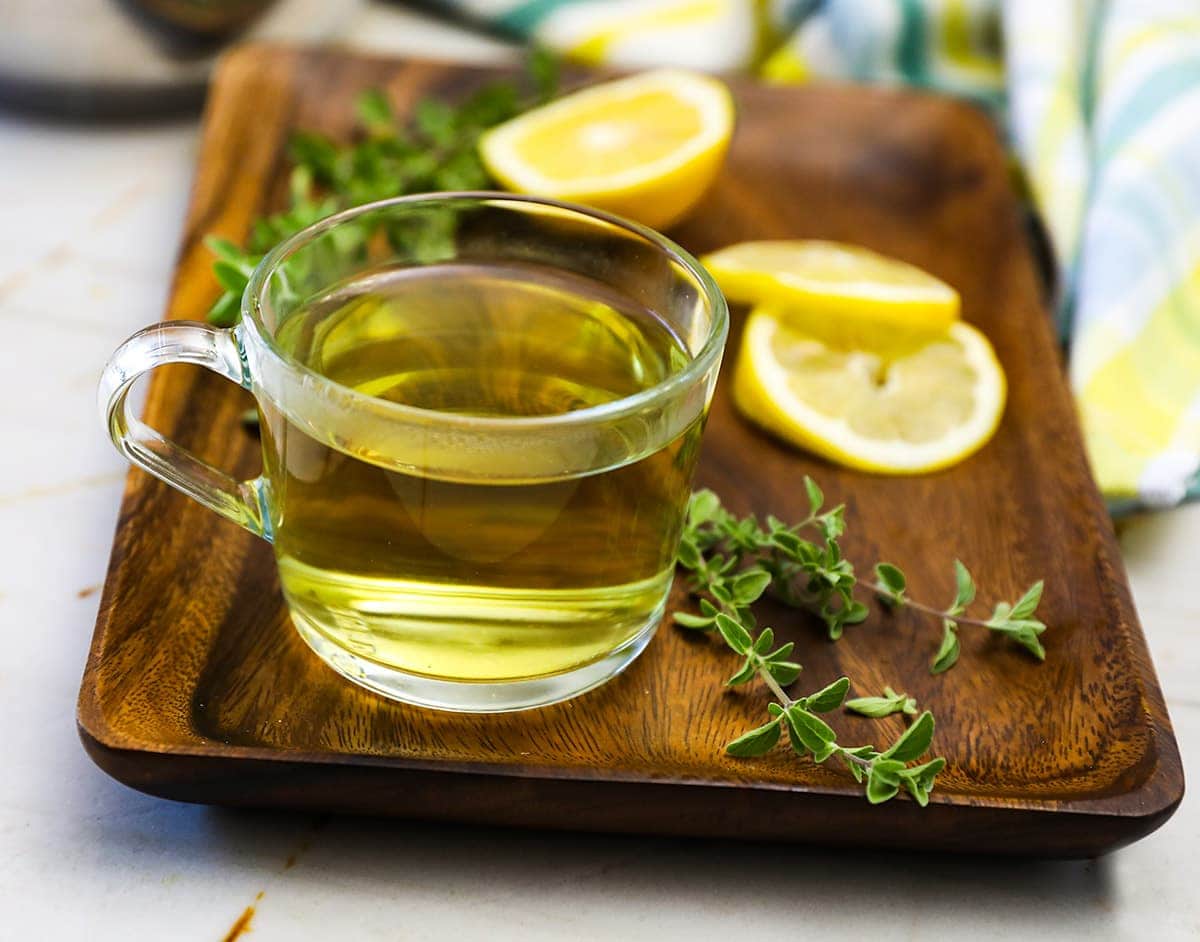 Oregano tea in a glass cup on a wooden background