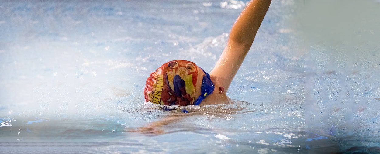 A Happy and Confident 6 year old Swimmer who is swimming front crawl in Wimbledon with Blue Wave Swim school