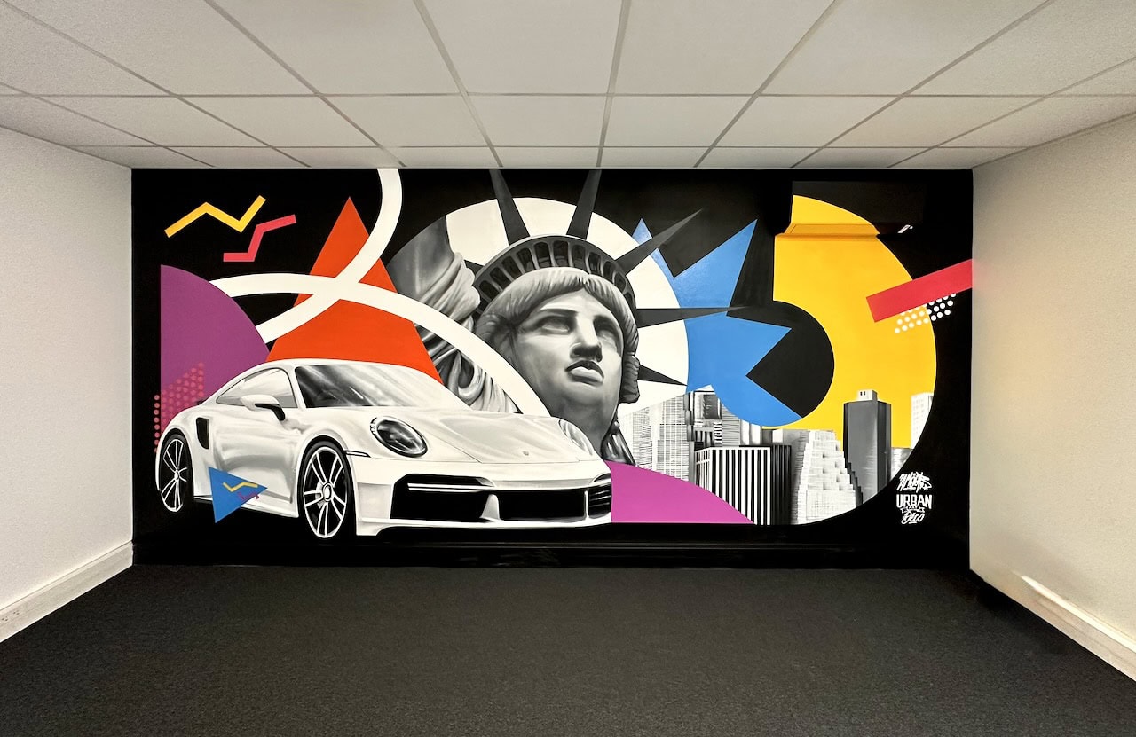 Fresque murale d'entreprise de 20 m² pour Norauto à Obernai : Porsche 911 blanche, statue de la Liberté et formes géométriques pop
