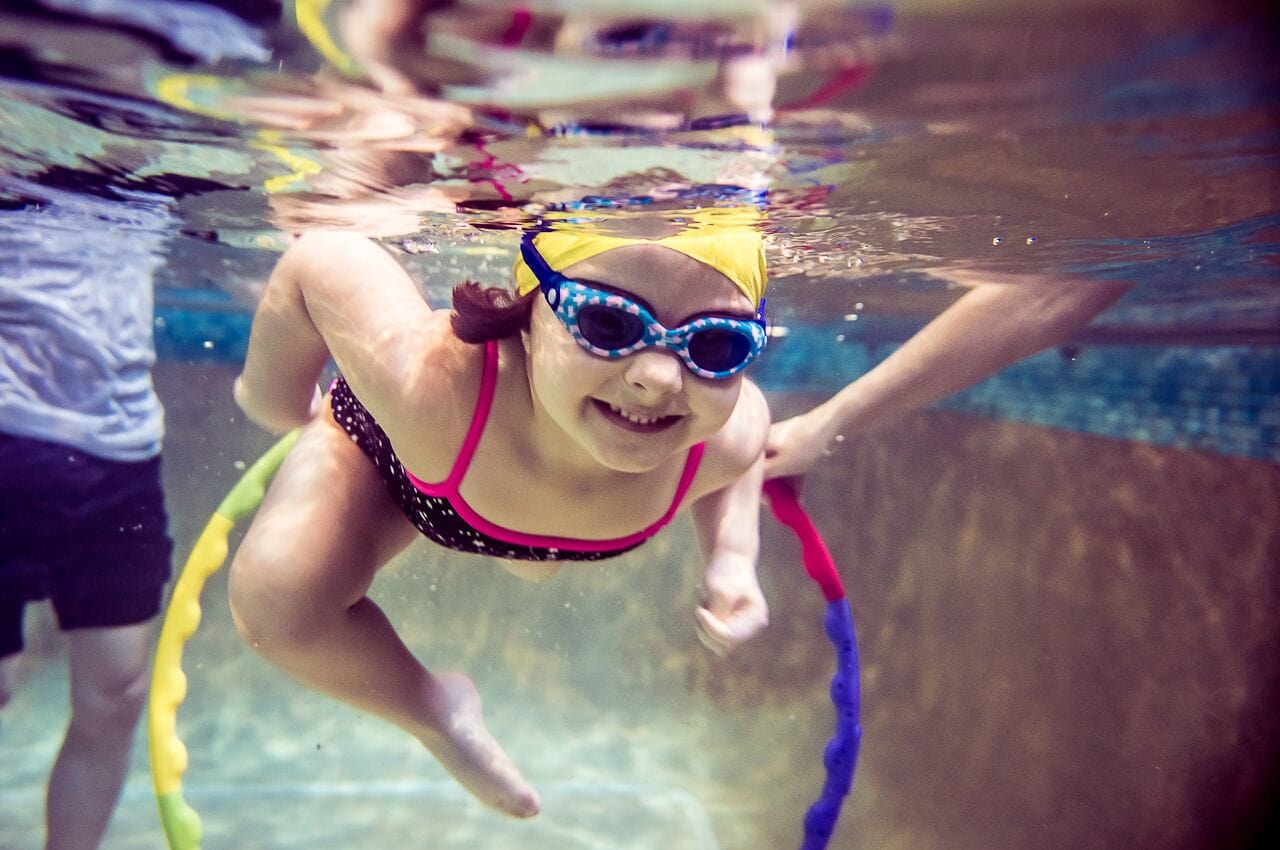 Child practicing underwater swimming skills during a swimming crash course in Southwest London
