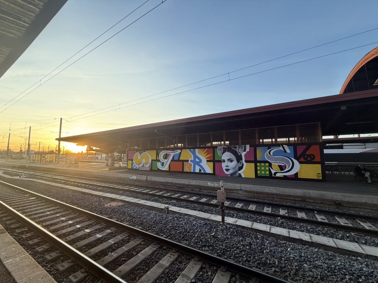 Fresque de Noël aux couleurs chatoyantes sur un quai de la gare de Strasbourg au coucher du soleil