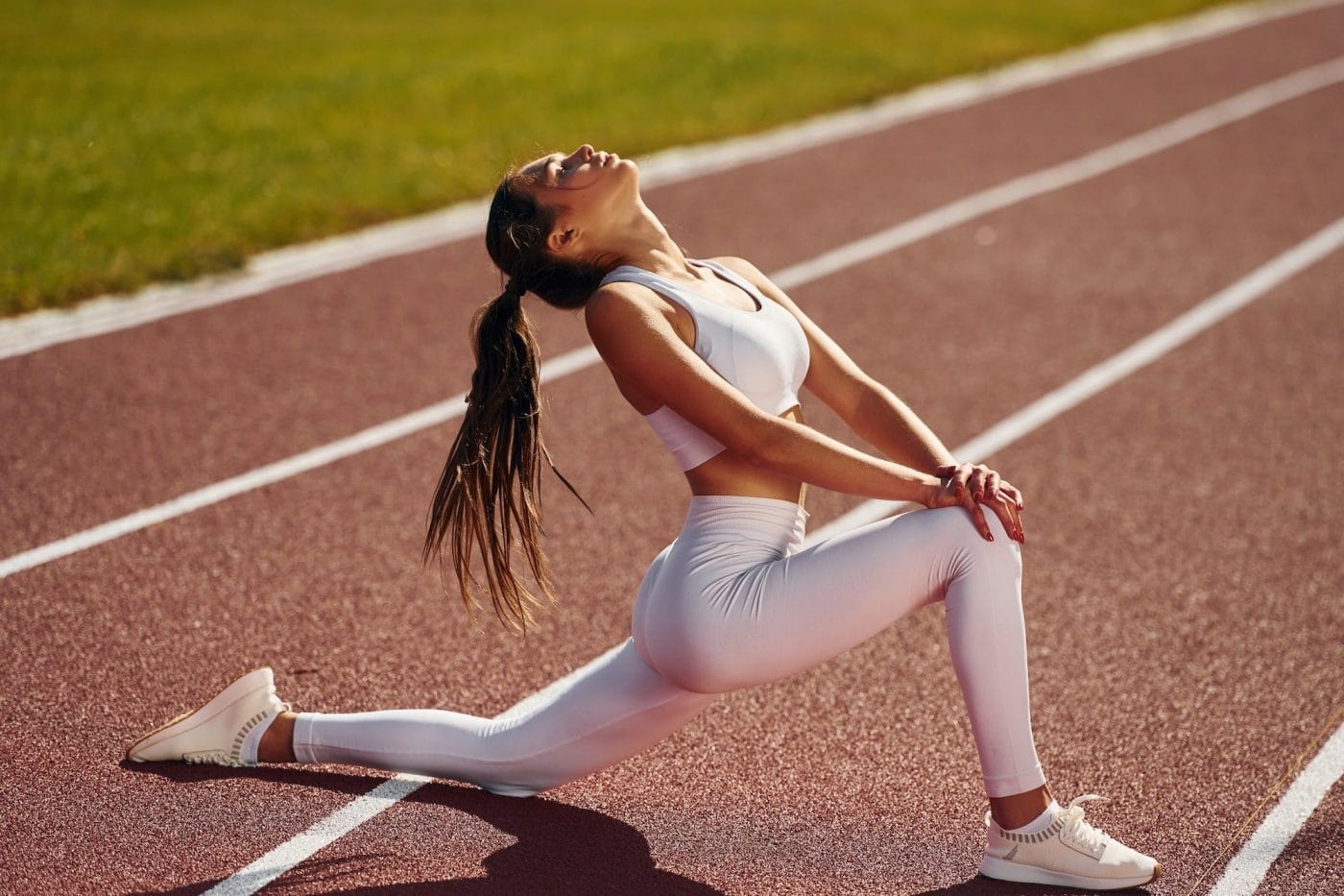 Stretching legs. Young woman in sportive clothes is exercising outdoors