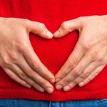 hands in heart shape over the stomach