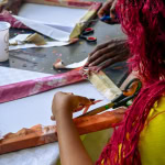 Participant cuts fabric strips during the hands-on Frame and Fabric Workshop at Galleria Shopping Mall.