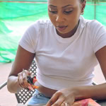 A focused participant cuts pink and orange fabric during the Frame and Fabric Workshop at Galleria.