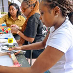 Three participants work together on fabric projects during the Frame and Fabric Workshop at Galleria.