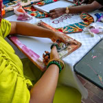 Several participants collaborate on colourful frame and fabric projects around a workshop table at Galleria.
