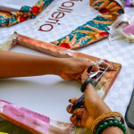 Close-up of a participant cutting patterned fabric during the Frame & Fabric Workshop at Galleria