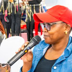 A guest in a red cap speaks into a microphone during Style, Shop & Sip with Connie Oluoch.