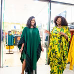 Connie Oluoch and a guest smile and talk beside clothing displays during Style, Shop & Sip at Galleria Shopping Mall.