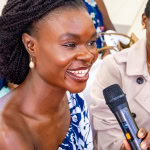 A smiling guest speaks into a microphone during the Style, Shop & Sip event