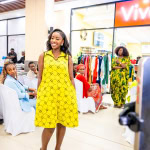A model presents a bright yellow dress during the Style, Shop & Sip fashion showcase