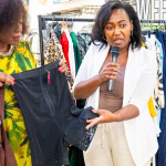 A presenter explains a black garment beside Connie Oluoch during a live styling demonstration