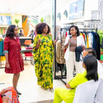Women take part in a Style, Shop & Sip presentation while guests watch from their seats.