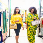 Two women model colourful outfits and handbags as they walk through the store during Style, Shop & Sip.
