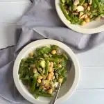 2 white plate over a blue napkin with three bean salad