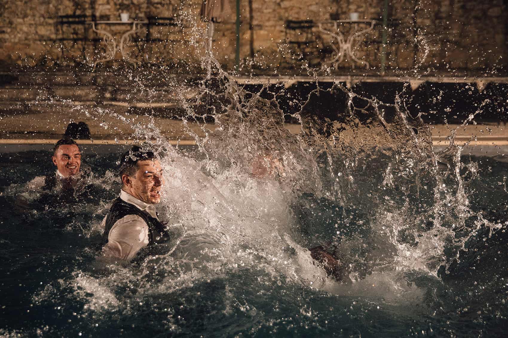 groomsmen jumping in swimming pool