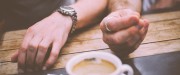 Hands gesturing next to coffee cup