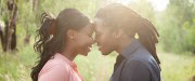 Married couple standing forehead to forehead and smiling