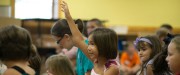 Little girl raising her hand during class