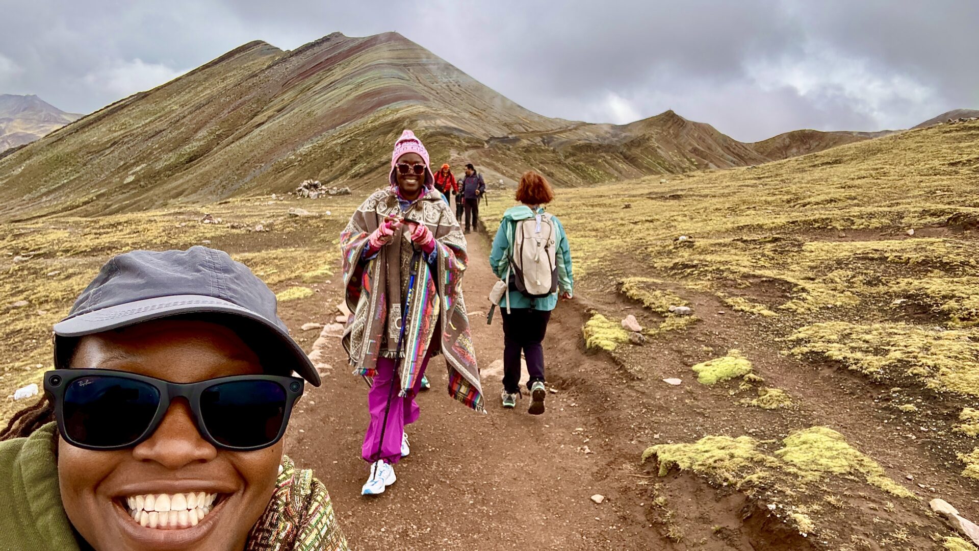 Travelers bundled in jackets and layers hiking the Palccoyo Rainbow Mountain. Traveling Black Women