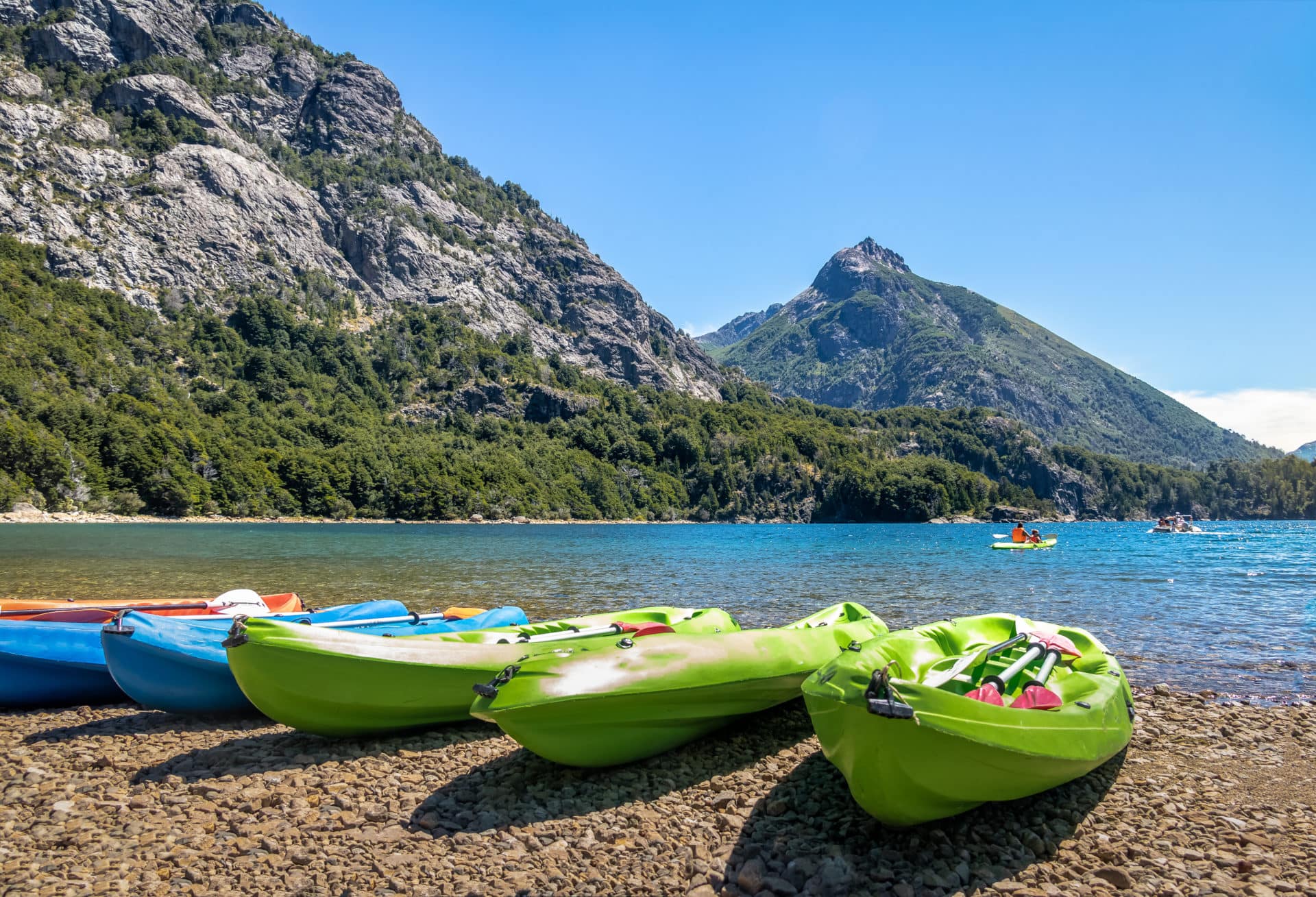 Colorful Kayaks in a lake surrounded by mountains at Bahia Lopez