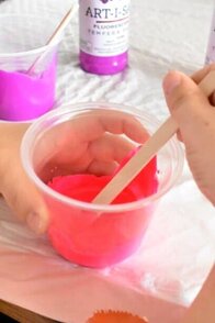 kid's hands mixing paint for pouring