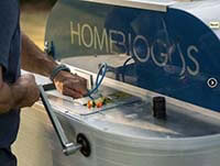 The TevaGas unit has a built-in grinder for food waste and a tap for rinsing off plates. The unit accepts food waste and animal droppings. (Source: HomeBioGas Ltd.)