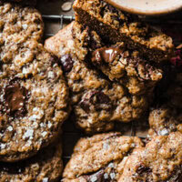 Estas Cookies de Avena y Chocolate con Mantequilla Tostada son una variación deliciosa de las clásicas cookies americanas. El toque de la avena aporta textura y lo que las hace aún más increíbles es el toque de mantequilla tostada con su aroma a frutos secos tostados. Quedan crujientes por fuera y blanditas por el centro, como una buena cookie (por eso no la llamo galleta como tal), y personalmente me encantan con un toque final de sal marina para ese contraste dulce-salado. | Receta de Paula's Apron