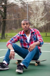 Best Ways to Contact a Woman Online 2 black man sitting on his skateboard in a ball park, stock photo, originally uploaded from Storyblocks with permission to ChiRhoDating.com