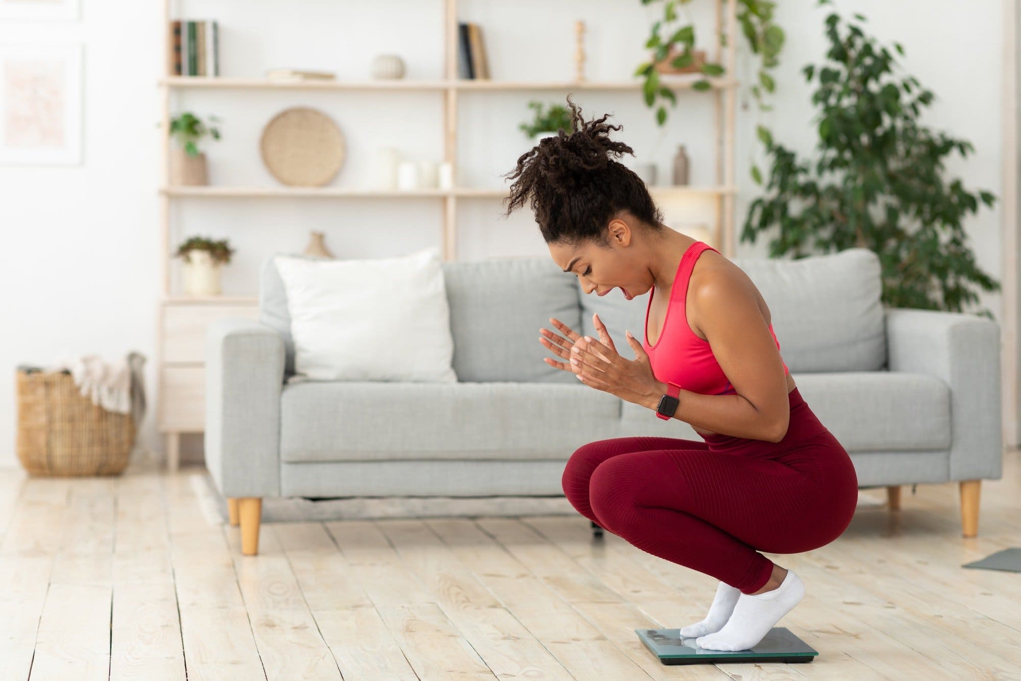 Black Lady Shouting Standing On Weight-Scales After Weight Gain Indoor