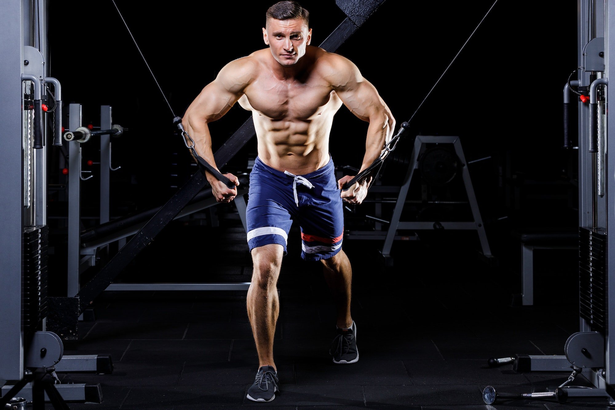 Male handsome bodybuilder gaining muscles in the gym