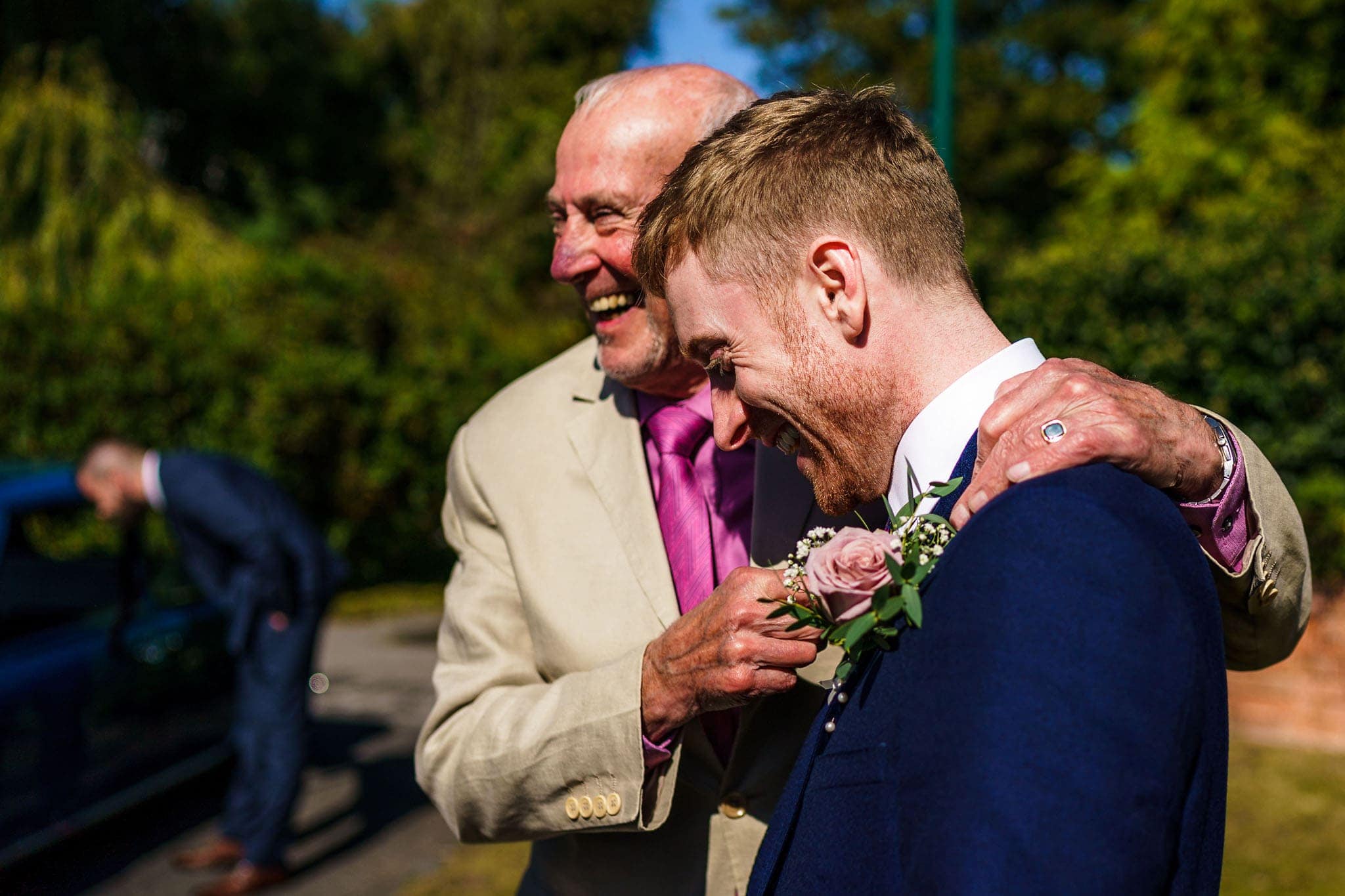 groom being embraced outside the church