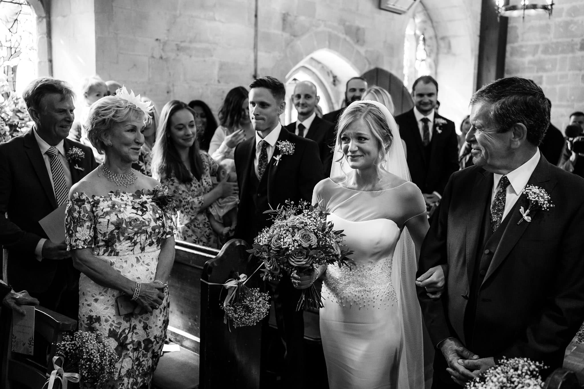 an emotional bride walking down the aisle