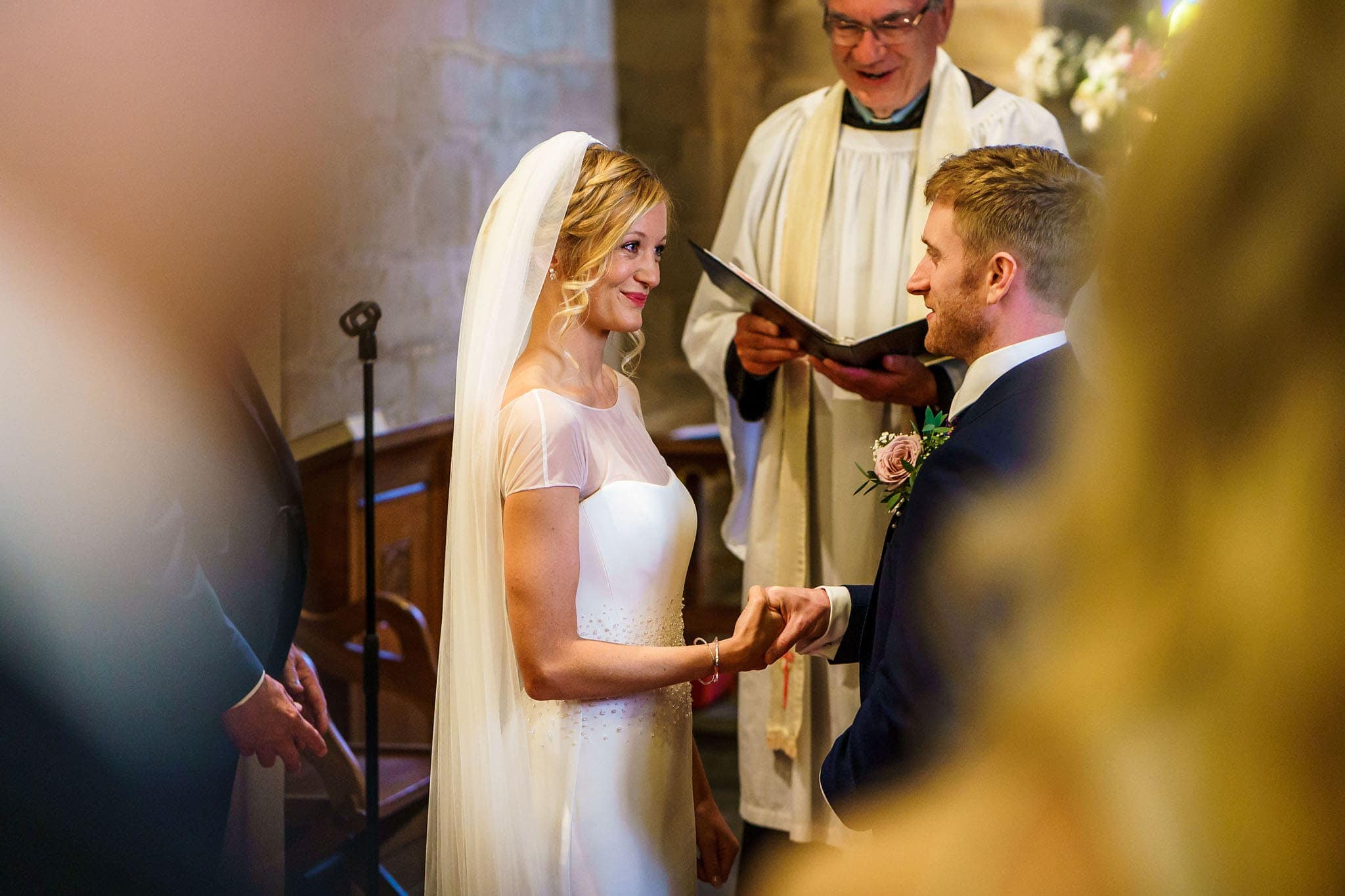 a smiley bride looking her groom in the eyes during their vows