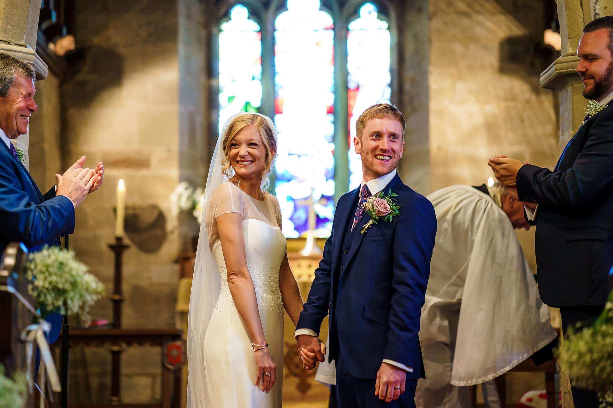 the happy couple being congratulated in the church