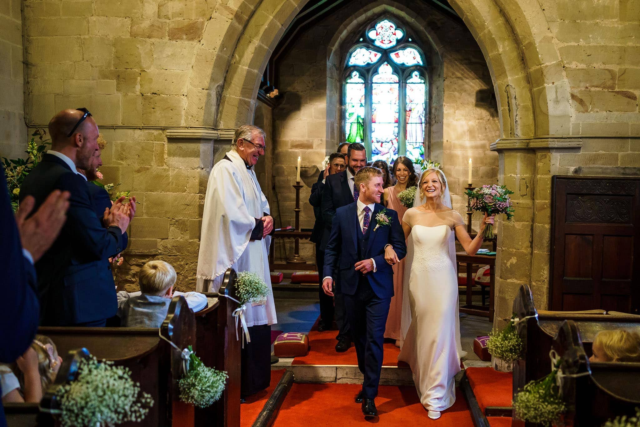 bride and groom walking back down the aisle at Holy Trinity church