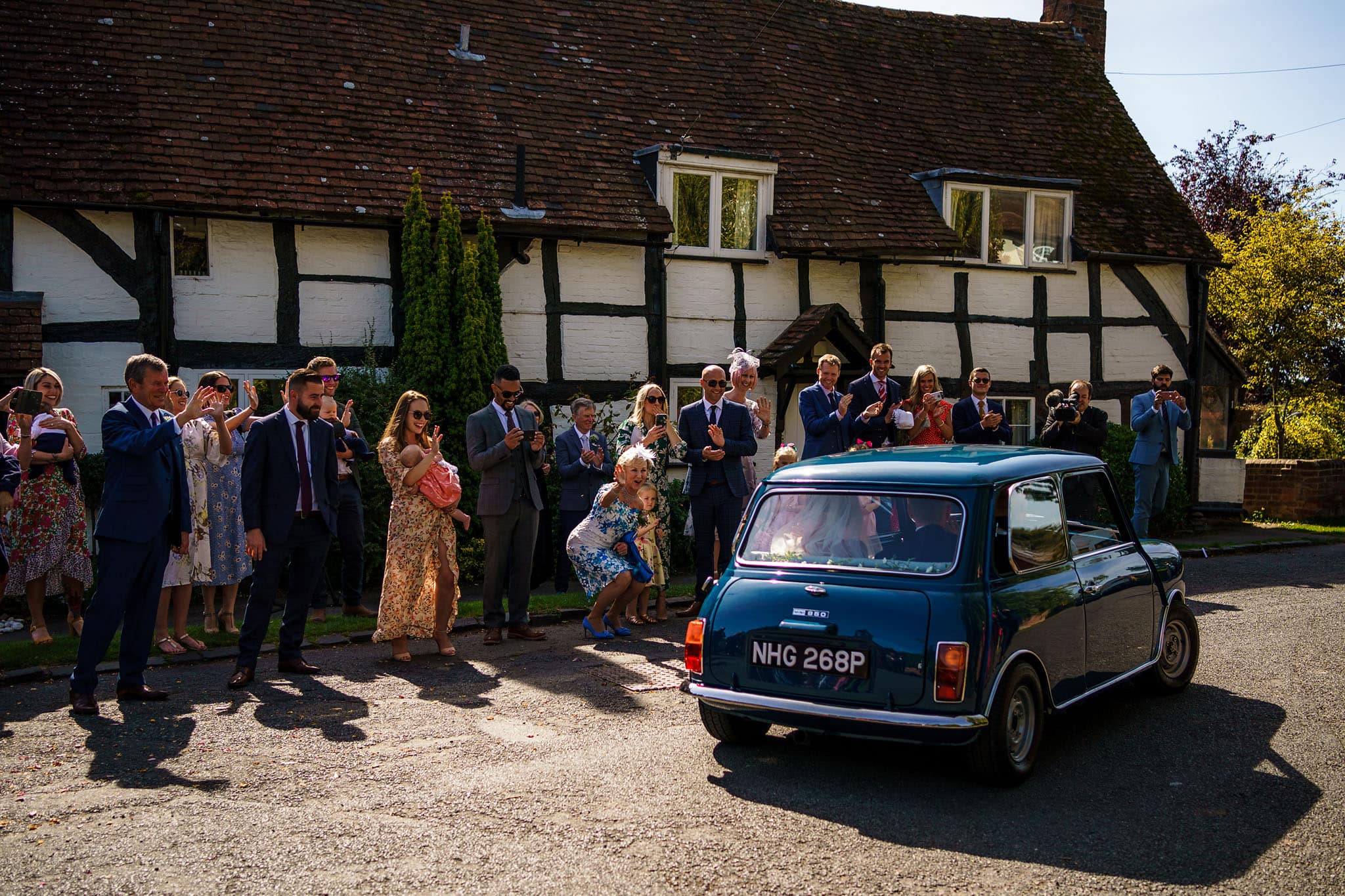 bride and groom leaving the church in their Mini