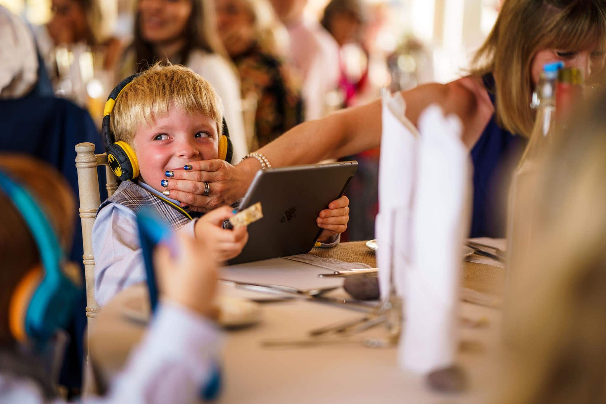a little boy being hushed by his mum for laughing during an emotional speech