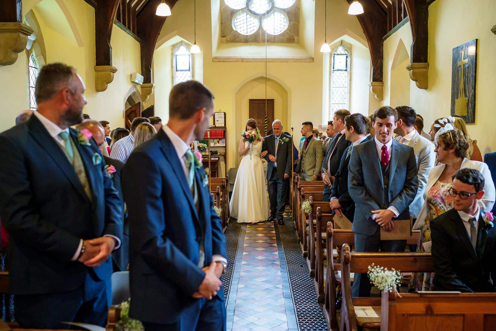 bride hiding behind her bouquet in the church