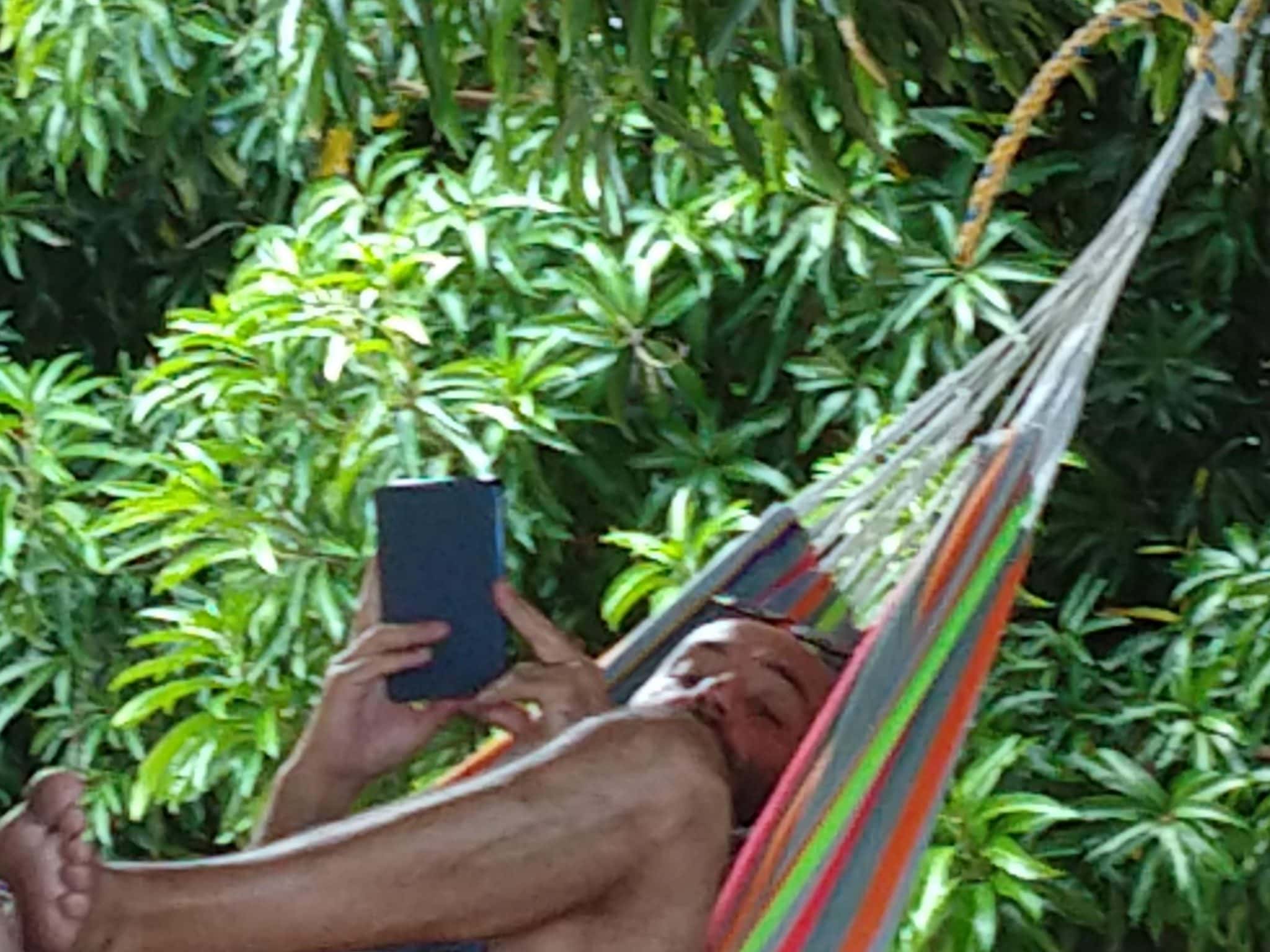 Joe enjoying a hammock and reading on his kindle