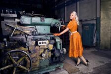 Женщина возле станков на предприятии