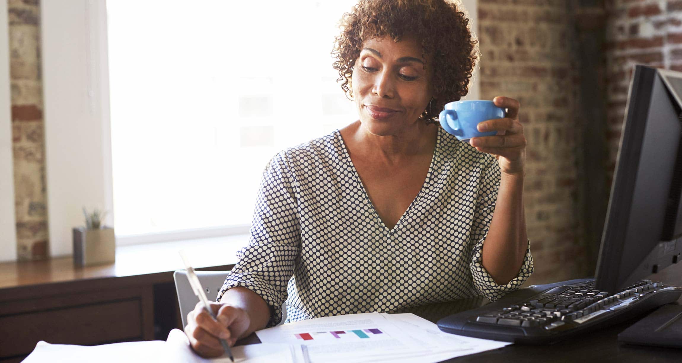 woman working while drinking coffee