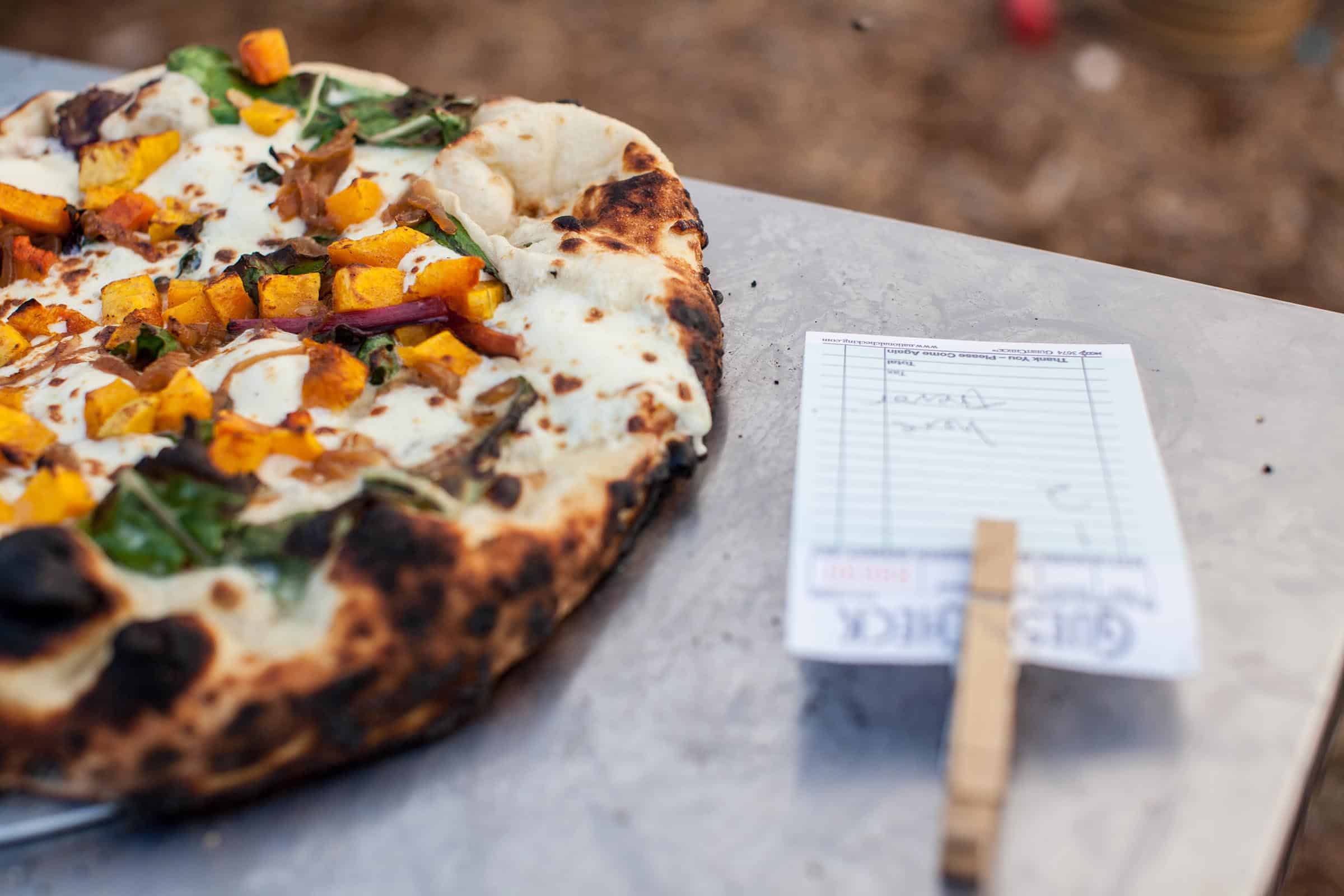 A close-up of a pizza and order ticket during a Thursdays at Troy event