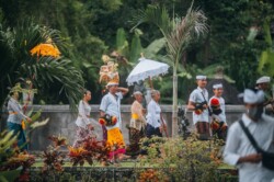 Hramska povorka u tradicionalnoj odeći sa ponudama i belim suncobranom