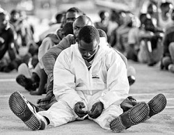 Migrants rest after disembarking in the Sicilian harbour of Augusta