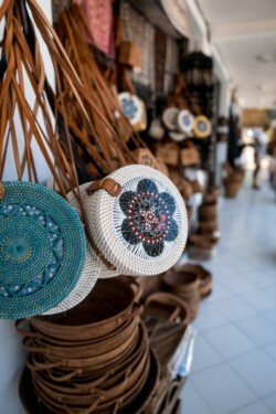 Okrugle pletene ratan torbe sa oslikanim šarama u prodavnici suvenira