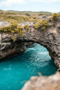Prirodni kameni luk iznad tirkizne uvale na obali Nusa Penide
