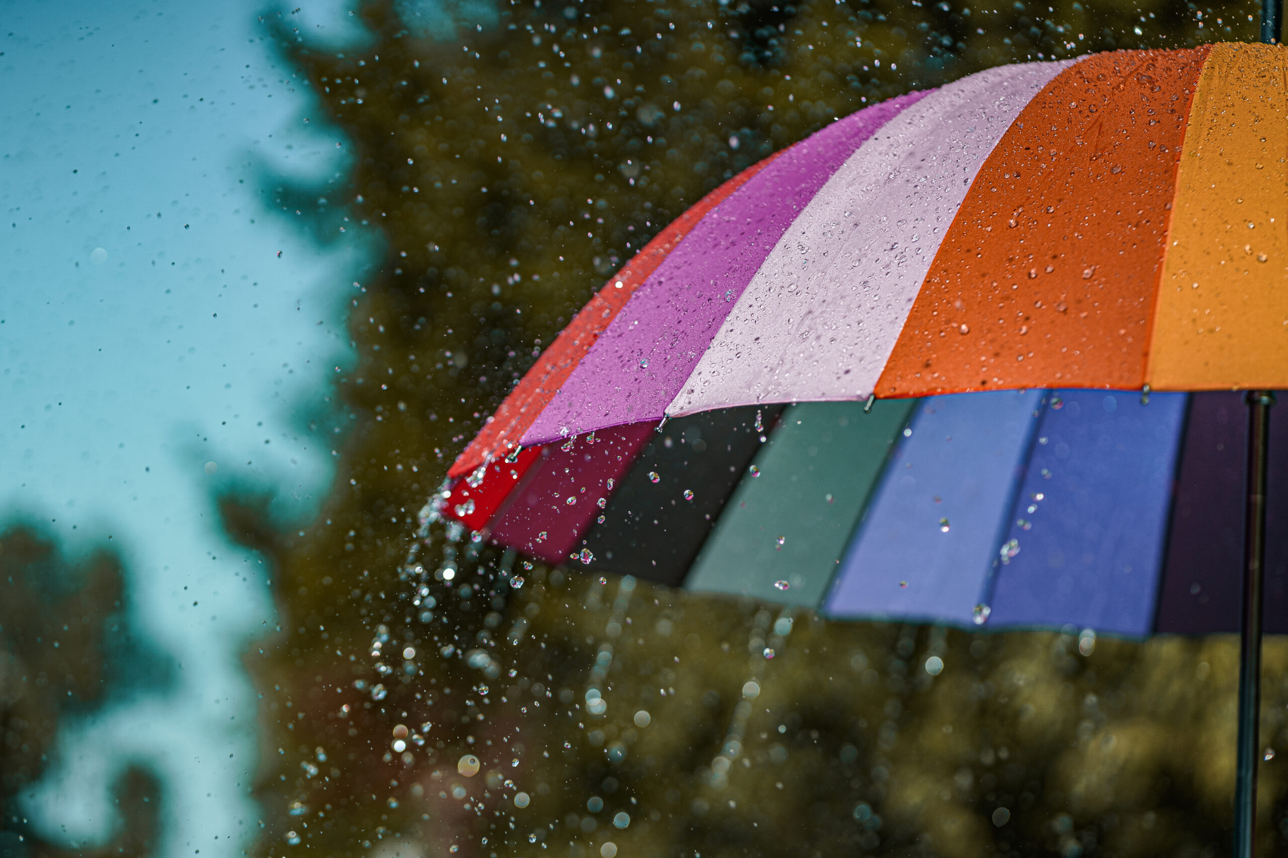 Bright colored rainbow umbrella in the rain weather Bright colored rainbow umbrella in the rain weather